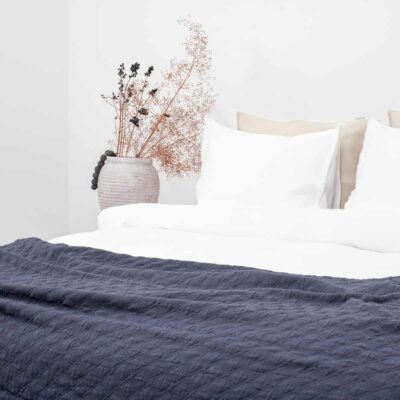 bed met donkerblauwe bedsprei Iris