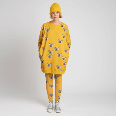 vrouw met must in okergeel en koala print