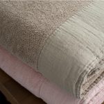 gevouwen handdoek in taupe en roze, dommelin sale handdoek van badstof met linnen band