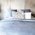 slaapkamer met houten muur en blauw dekbedovertrek