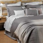 opgemaakt bed met plaid en kussens