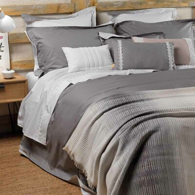 opgemaakt bed met plaid en kussens