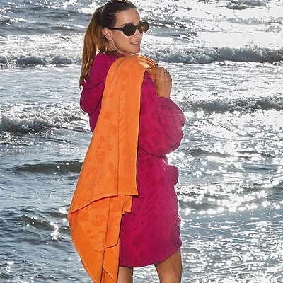 fel gekleurde dames badjas met strandlaken op het strand