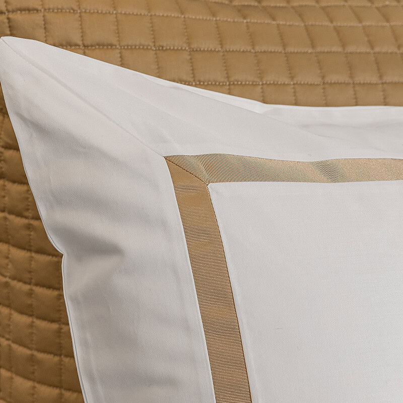 detail van kussensloop hotel dekbedovertrek katoen satijn in de kleur wit - goud