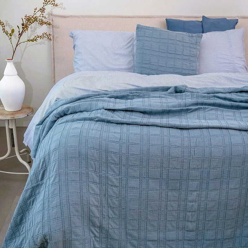 bed met blauwe katoenen bedsprei