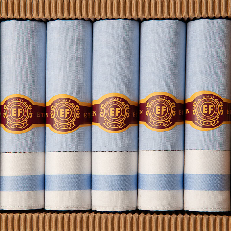 lichtblauwe heren zakdoeken opgerold in sigarendoosje