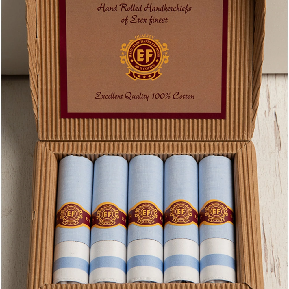lichtblauwe heren zakdoeken opgerold in sigarendoos