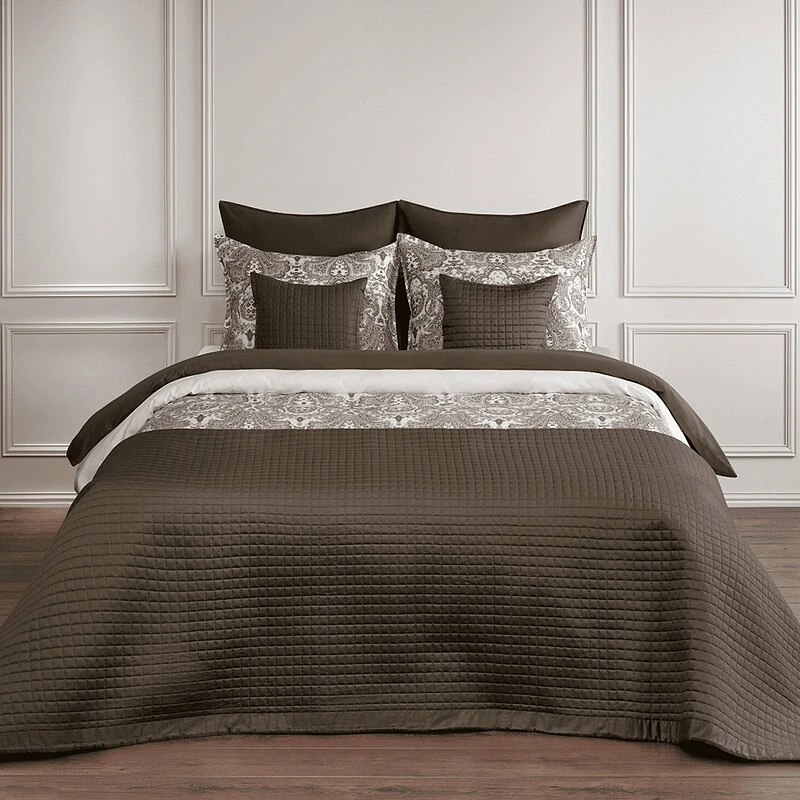 slaapkamer met luxe bedsprei en satijnen dekbedovertrek