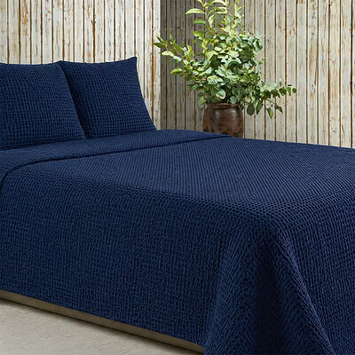 slaapkamer met donkerblauwe bedsprei