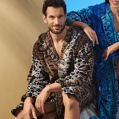 man in luxe bruine badjas met capuchon